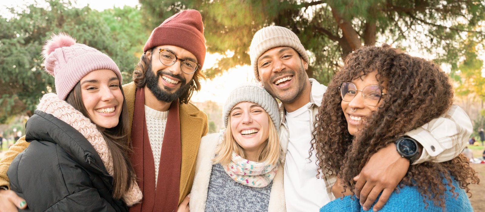 A diverse group of friends smiling together outdoors, representing community and solidarity