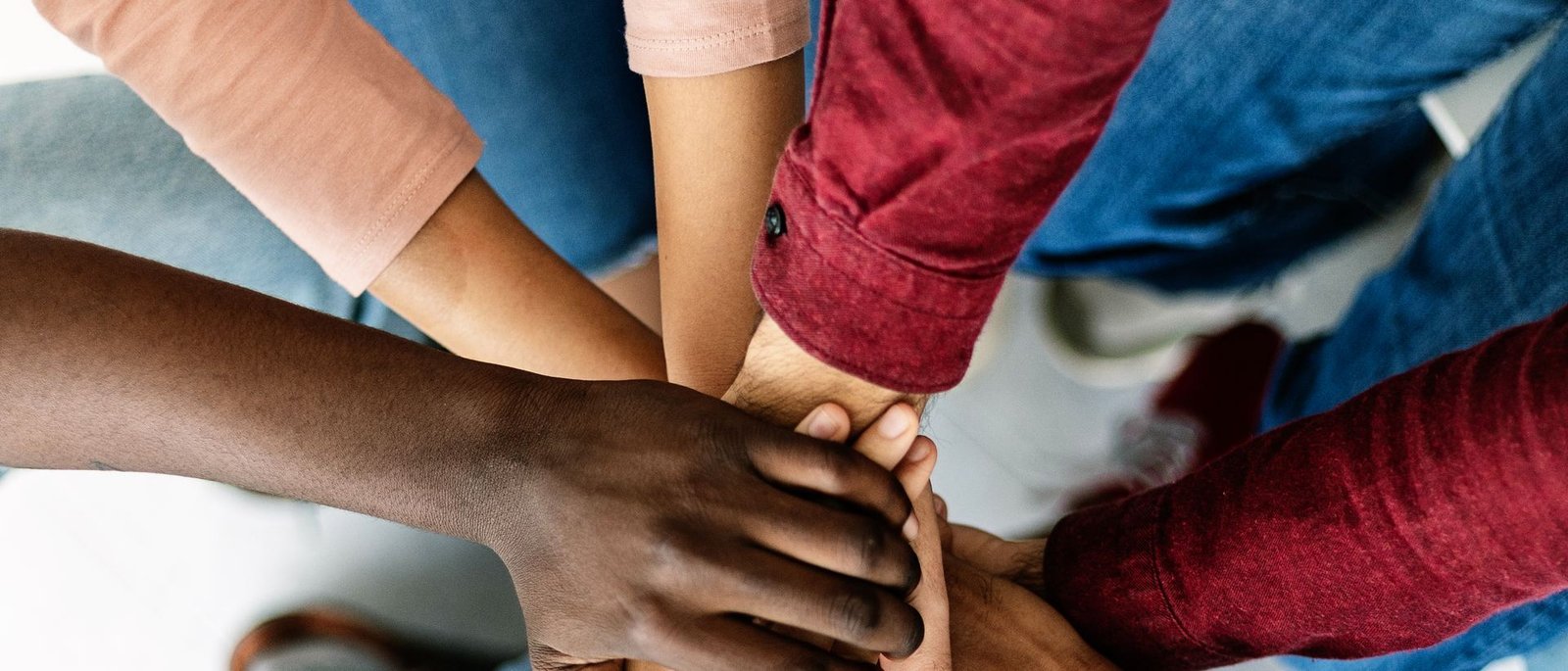 Volunteers joining hands together in unity and teamwork