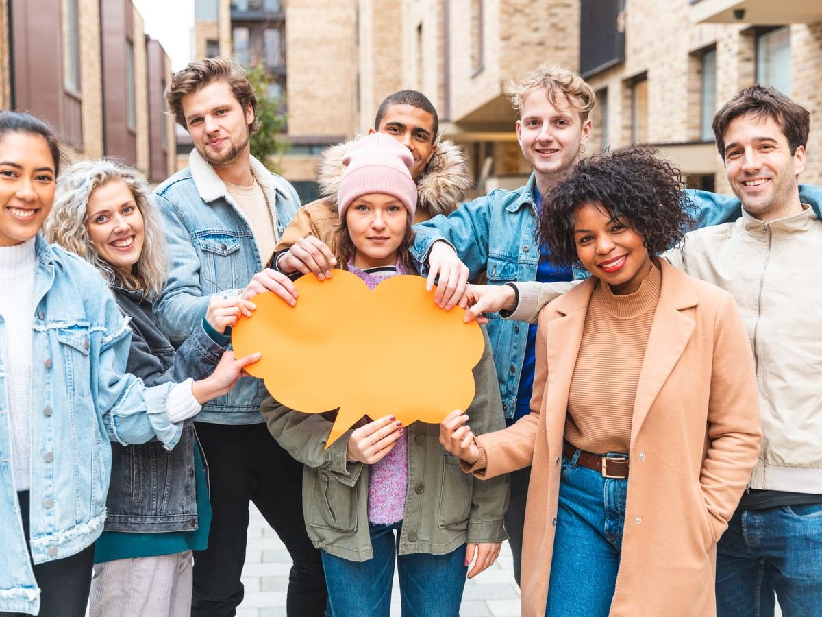 A group of friends holding an orange speech bubble, representing open dialogue